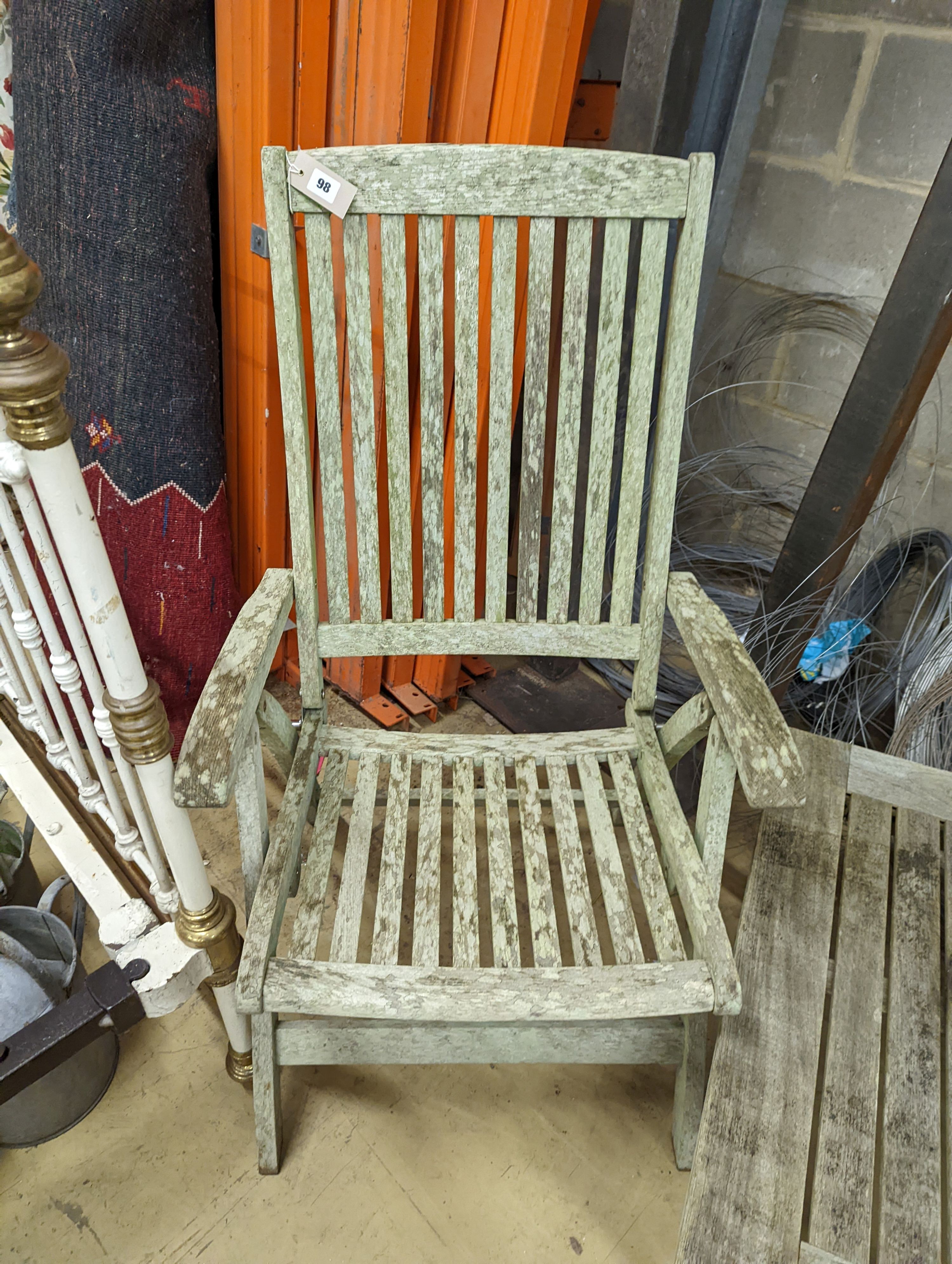 Two weathered teak folding garden armchairs and a low table